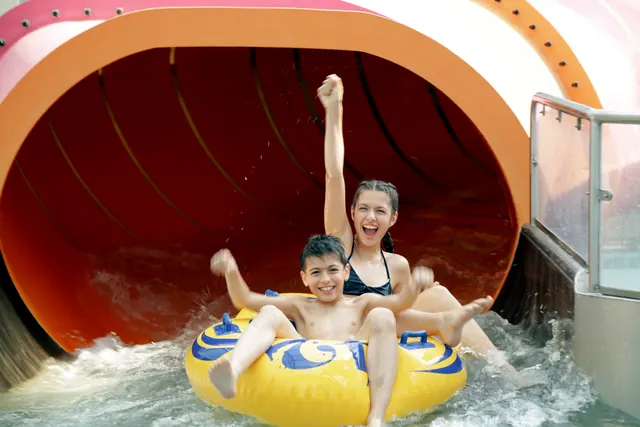 Familie auf einem Reifen am Ende einer Wasserrutsche