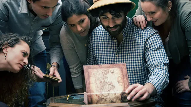 Gruppe untersucht gemeinsam eine Karte im Escape Room